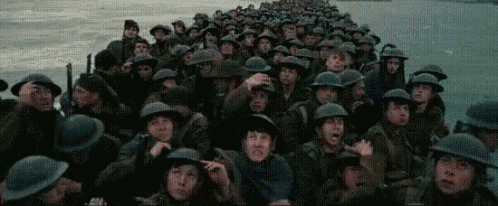 a large group of soldiers wearing helmets are standing on top of a bridge .