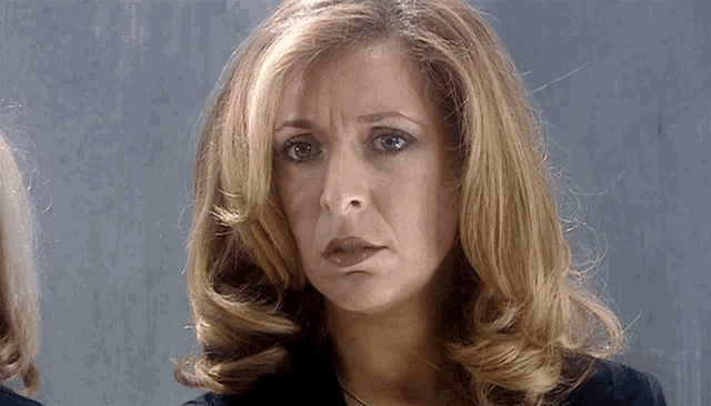 a close up of a woman 's face with a sad look on her face