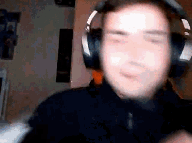 a man wearing headphones is making a funny face while looking at the camera .