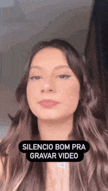 a close up of a woman 's face with the words silencio bom pra gravar video below it