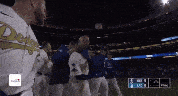 a group of baseball players are standing on a field with a scoreboard that says det 5 lad 8