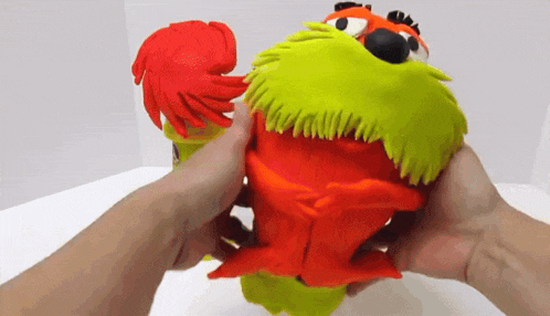 a person is holding a toy that looks like a chicken