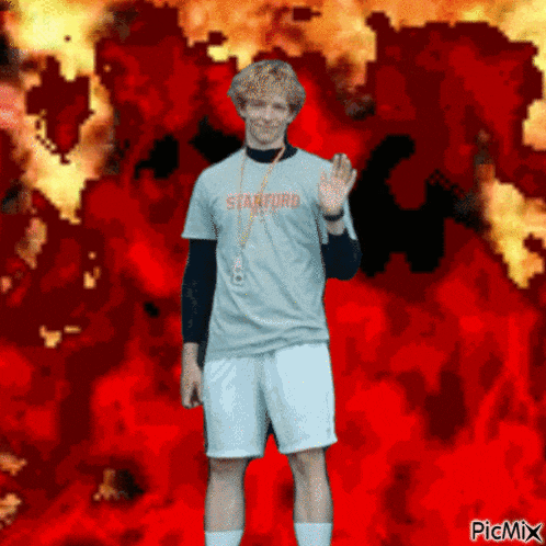 a man wearing a shirt that says stanford is standing in front of a fire background