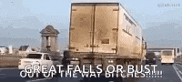 a truck is driving down a highway with the words `` great falls or bust out of the way bitches '' written on it .