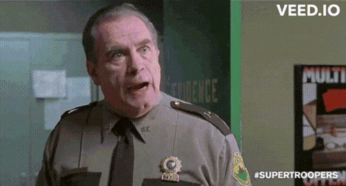 a man in a sheriff 's uniform is standing in front of a poster that says " multi "