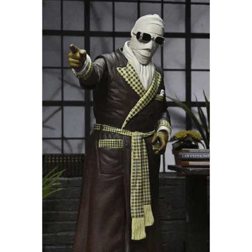 a statue of a man wearing a robe and goggles points his finger