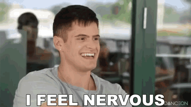 a man is sitting at a table and smiling while saying `` i feel nervous '' .