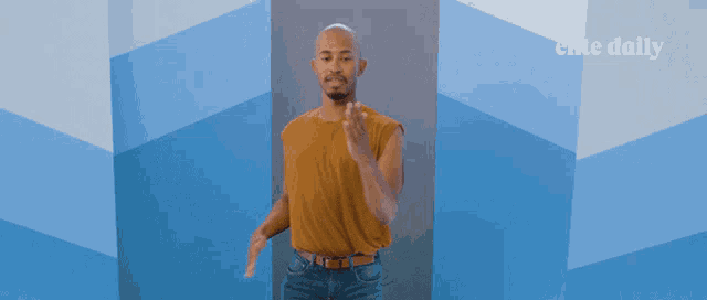 a man is dancing in front of a wall that says elite daily on it