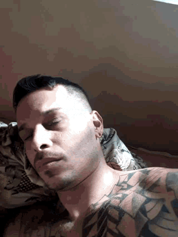 a man with a tattoo on his chest is laying down