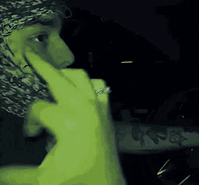 a person wearing a bandana and a ring is making a middle finger gesture .