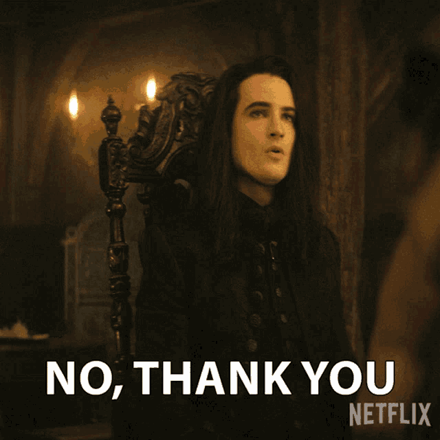 a man with long black hair is sitting in a chair and says no thank you