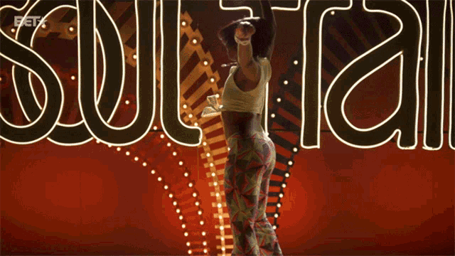a woman is dancing in front of a sign that says " soul train "