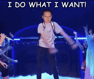 a man is dancing on a stage with the words i do what i want above him