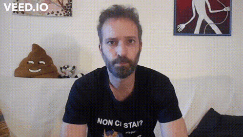 a man with a beard wears a black shirt that says non ci stai