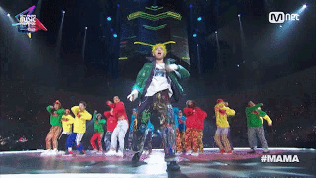a group of people dancing on a stage with the word mama on the bottom right