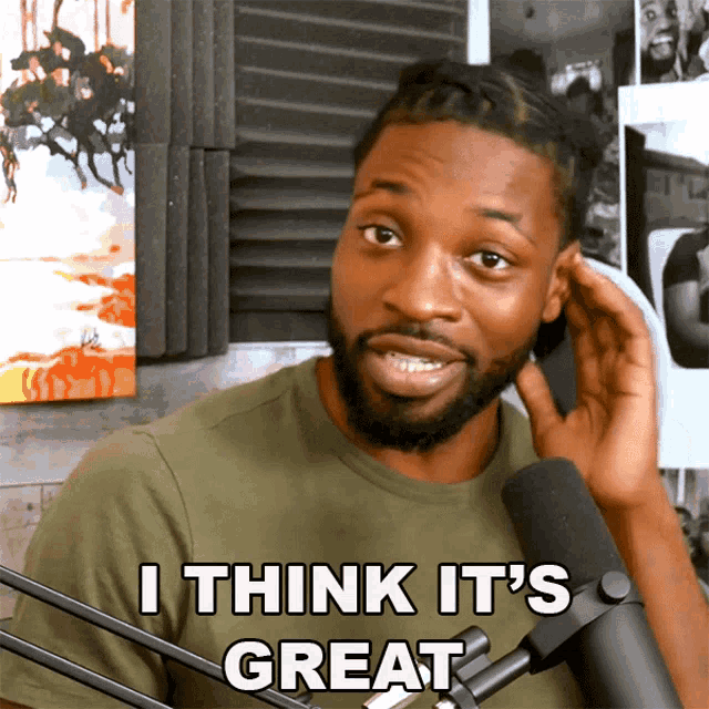 a man in front of a microphone is saying i think it 's great