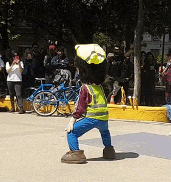 a man in a yellow vest with the number 1 on it stands on a sidewalk