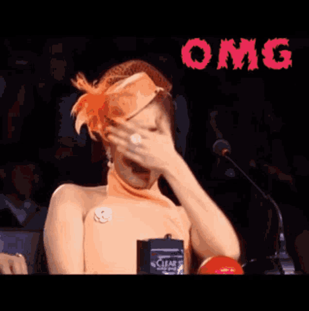 a woman singing into a microphone with the word omg written on the bottom