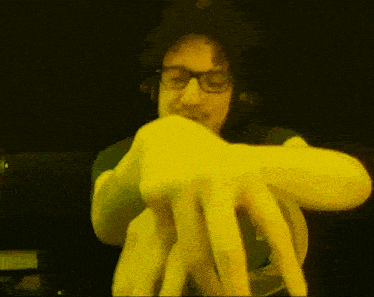 a man wearing glasses and headphones holds a yellow object in his hands