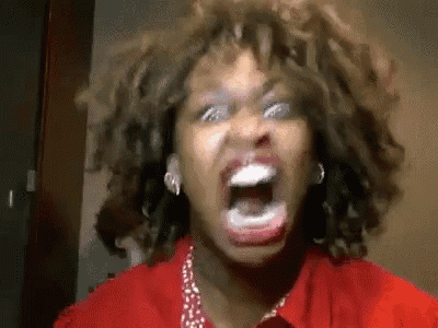 a woman with curly hair is screaming with her mouth open .