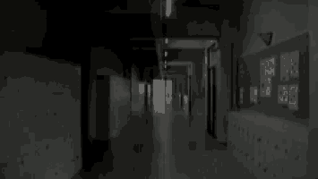 a long hallway with a bulletin board on the wall