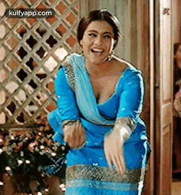 a woman in a blue dress is standing in front of a door .