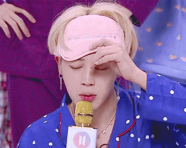 a man wearing a sleep mask is holding a microphone