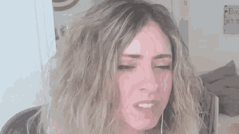 a woman with blonde hair is making a funny face while wearing headphones and making a funny face .