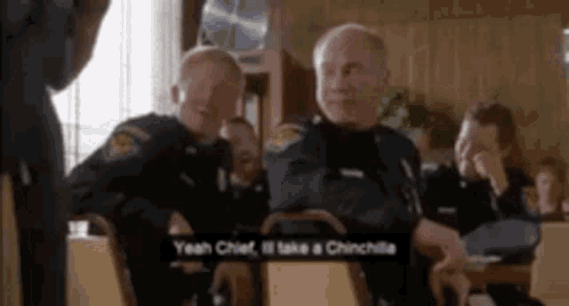 a group of police officers are sitting at a table in a restaurant .