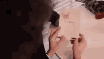 a person is holding a card that says `` i 'm sorry '' in their hands .