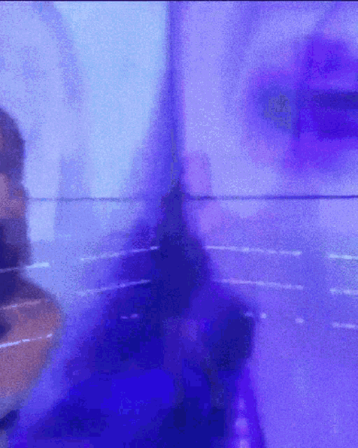 a blurry picture of a person 's face with a purple light behind them