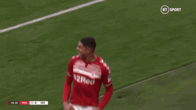 a soccer player wearing a red shirt and white shorts is celebrating a goal .