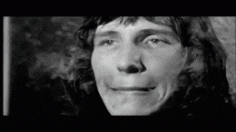 a black and white photo of a man making a face .