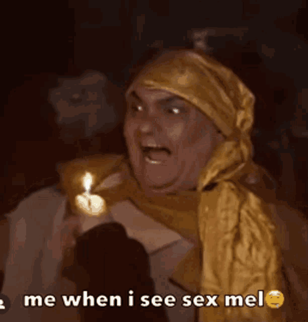 a man with a scarf around his head holds a lit candle and says me when i see sex me