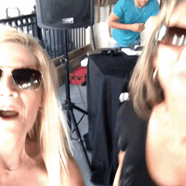 a woman wearing sunglasses is standing next to another woman
