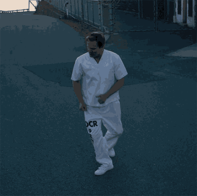 a man wearing a white scrub top and white pants that say cdr