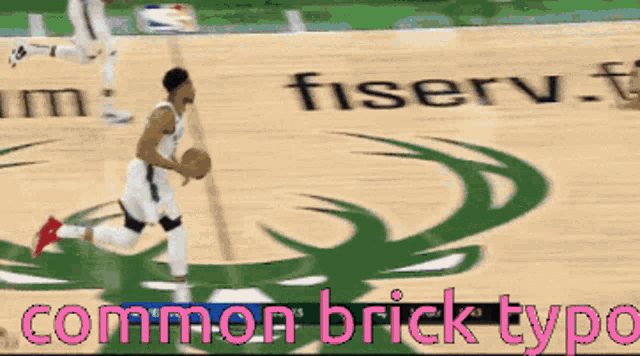 a basketball player dribbles the ball in front of a fisserv logo
