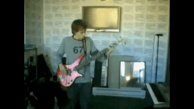 a man playing a guitar with a shirt that says 67 on it