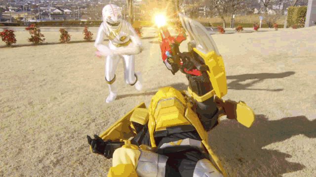 a white ranger and a yellow ranger are fighting