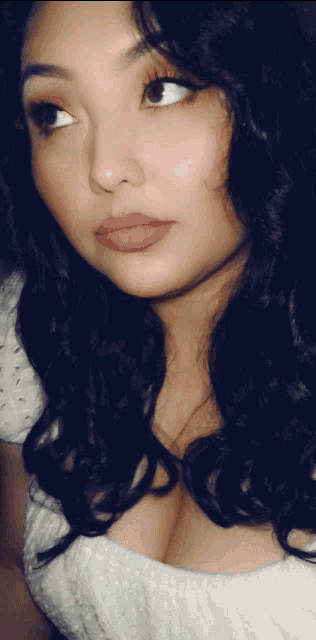 a close up of a woman 's face with a white top on