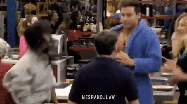 a man in a blue robe is standing in front of a crowd of people in a store .