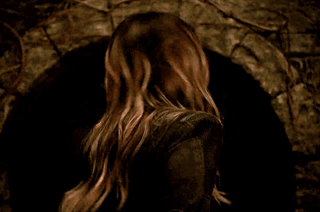 a woman with a surprised look on her face is standing in a dark tunnel