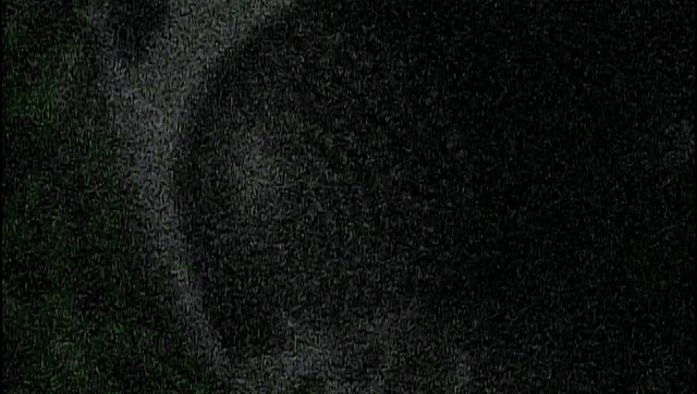 a silhouette of a person standing in front of a cross on a green background .