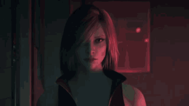 a woman with red hair is standing in front of a red light .
