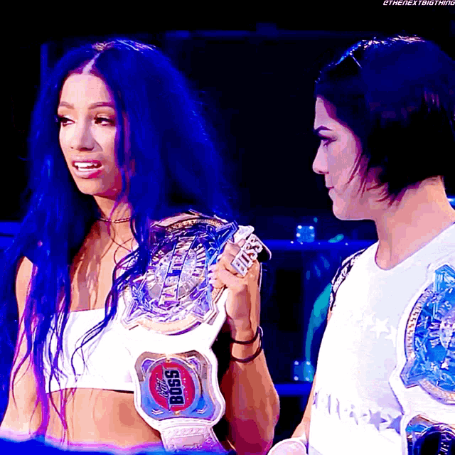 two women are standing next to each other and one has a belt that says boss