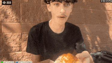 a young man is eating a pizza with a time of 3:50