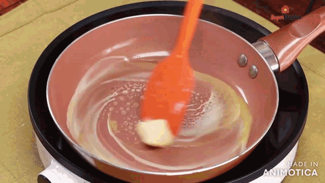 a spatula is stirring butter in a frying pan .