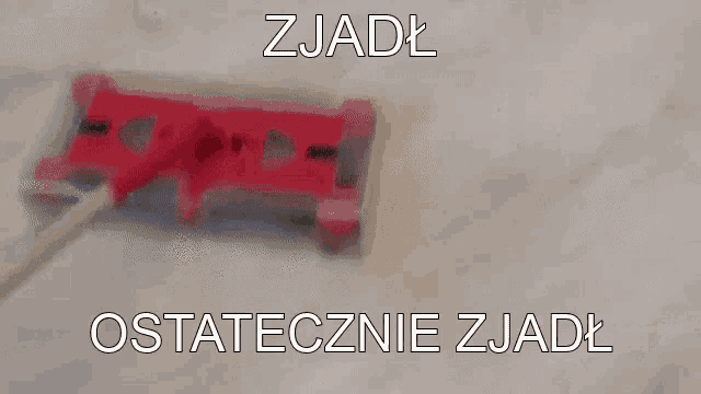 a red mop is being used to clean a marble floor in a foreign language .