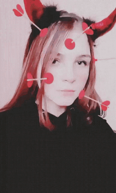 a girl wearing devil horns and hearts on her head