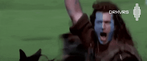 a man with a blue and red mask on his face is raising his arms in the air .